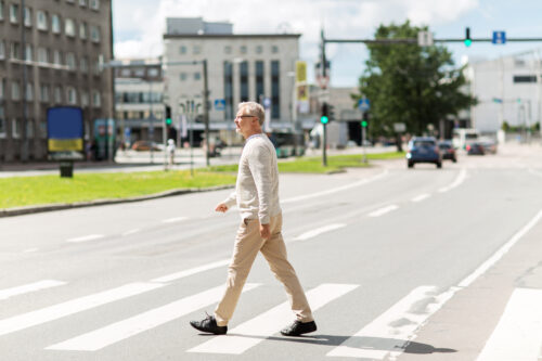 pedestrian crossing the street in crosswalk