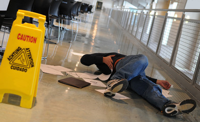 person on the floor after slip and fall with wet floor sign
