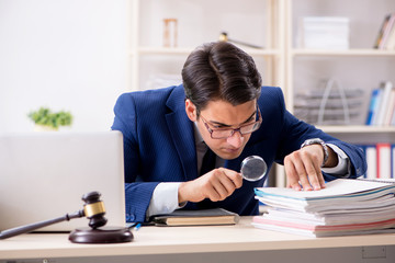 man with gavel and magnifying glass with papers