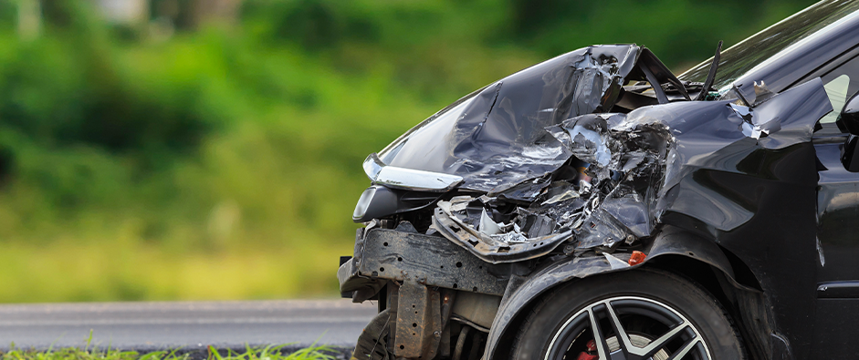 A totaled black sedan closeup; Car Accident Attorney in Middlesex County, NJ concept image