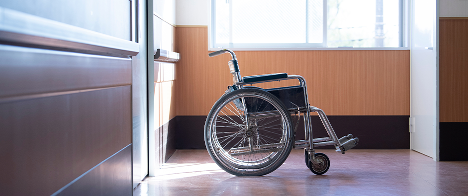 an empty wheelchair sitting in a hallway; East Brunswick Personal Injury Lawyer concept image