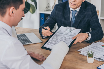 man with cast and lawyer with papers