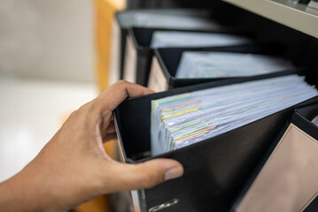 person pulling binder out of stack