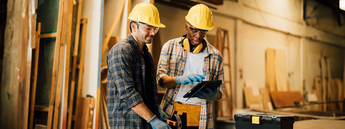 two construction workers reviewing a clipboard