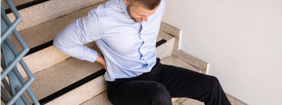 man on staircase with his hands on his back