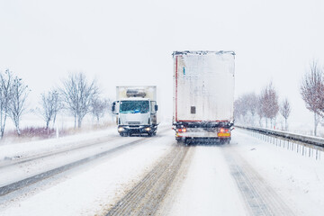 two trucks driving on snowy winter roads