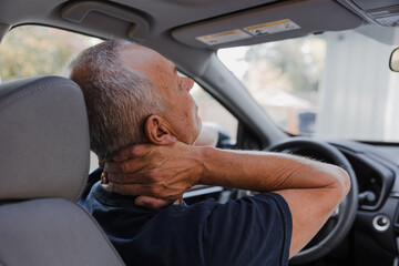 man clutching neck in car after accident