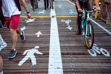 bicyclist in bike lane next to people walking in pedestrian lane