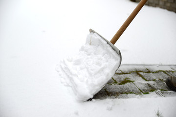 shovel clearing snow on sidewalk